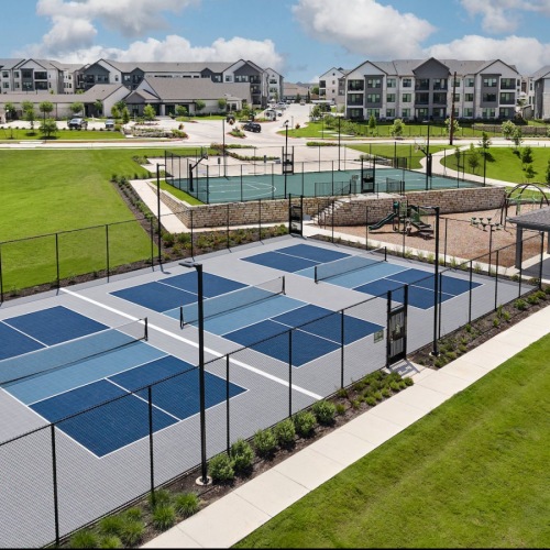 All the comforts of luxury living a row of pickle ball courts surrounded by grass