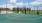 a basketball court with grass and buildings 