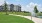 a walking path with grass and a building behind it